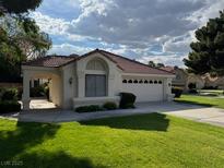 Charming single-story home with a well-maintained lawn and attached two-car garage at 5401 Painted Sunrise Dr, Las Vegas, NV 89149