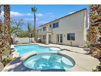 Resort-style backyard featuring a sparkling pool, spa, and lush tropical landscaping, perfect for relaxing and entertaining at 1557 Sabatini Dr, Henderson, NV 89052