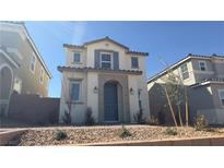 Charming two-story home with a blue door, symmetrical design, and desert landscaping at 2713 Abrantes Pl, Henderson, NV 89044