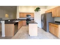 Well-lit kitchen with stainless steel appliances, spacious countertops and island, perfect for cooking and entertaining at 4717 Mohawk River Ave, North Las Vegas, NV 89031