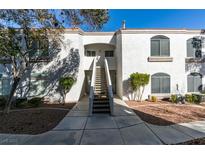 Condominium exterior with well-manicured landscaping, red tile roof and stairs to the second level at 700 Carnegie St # 122, Henderson, NV 89052