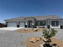 Charming single-story home with a gravel yard, tiled roof, and a two-car garage at 790 Fort Churchill Rd, Pahrump, NV 89060