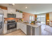 Modern kitchen features stainless steel appliances, white cabinetry, and granite countertops at 10982 Rollingford Ave # Lot 7, Las Vegas, NV 89166