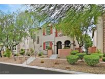 Charming two-story townhome featuring desert landscaping, red shutters, and a welcoming entrance at 11023 Ketchikan St, Las Vegas, NV 89179