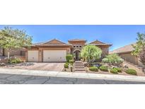 Charming single-story home with a tile roof, stone accents, and a meticulously manicured front yard at 2509 Chateau Napoleon Dr, Henderson, NV 89044