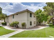 Condo exterior with desert landscaping and mature trees on a sunny day at 2633 S Durango Dr # 202, Las Vegas, NV 89117