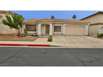 Charming single-story home featuring a 2-car garage, desert landscaping, and a cozy front porch at 2865 Destino Ln, Henderson, NV 89074