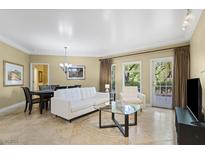 Bright living room with a white sofa set, glass table, tile flooring, and natural light from the windows at 30 Strada Di Villaggio # 118, Henderson, NV 89011