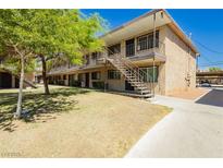 Apartment building featuring a stucco exterior, stair access, and landscaping at 3719 Hazelwood St # 16, Las Vegas, NV 89119