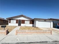 Traditional single-story home featuring a two-car garage and desert landscaping in front at 4303 Paramount St, Las Vegas, NV 89115