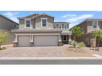 Two-story home featuring a three-car garage and desert landscaping at 10058 Matter Overlook Dr, Las Vegas, NV 89178