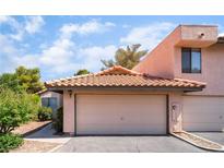 A home exterior with a two-car garage and a red-tiled roof against a backdrop of blue skies and greenery at 3629 Laguna Verde Way, Las Vegas, NV 89121
