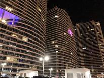 Exterior night view of modern high rise buildings with illuminated windows and balconies at 4575 Dean Martin Dr # 303, Las Vegas, NV 89103