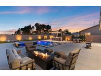 Beautiful backyard featuring a sparkling pool, hot tub, fire pit, bar, and plenty of seating for entertaining at 5081 Notting Hill Ave, Las Vegas, NV 89139