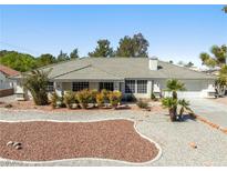 Charming single-story home featuring mature landscaping with drought tolerant desert scape and a spacious two car garage at 2040 Tucuman Ave, Pahrump, NV 89048