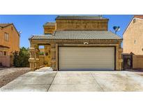 A home featuring a two-car garage and landscaped front yard at 5754 Cinnabar Ave, Las Vegas, NV 89110