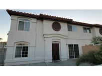 Inviting townhouse featuring a solid wood front door and an arched window above for unique curb appeal at 3930 Starfield Ln, Las Vegas, NV 89147