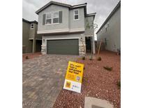 Two-story home featuring gray stucco, stone accents, a two-car garage, and drought-resistant landscaping at 6604 Bowery St, Las Vegas, NV 89148