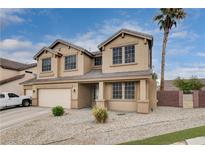 Inviting two-story home featuring a well-kept lawn, desert landscaping, and neutral color palette at 108 Parker Ranch Dr, Henderson, NV 89012