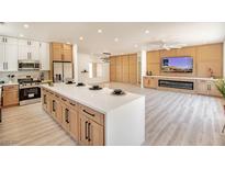Open kitchen and living area featuring a large island, modern appliances, and hardwood flooring at 2561 Terrytown Ave, Henderson, NV 89052