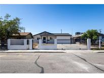 Charming single-story home featuring a gated front yard, white facade, and well-maintained landscaping at 3601 Broadway Ave, North Las Vegas, NV 89030