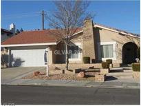 Charming single-story home featuring a brick chimney, arched entry, and low maintenance front yard at 4338 La Jara Drive, Las Vegas, NV 89120