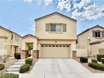 Two-story home featuring a two-car garage, neutral paint, green shutters, and low-maintenance landscaping at 5517 Overlook Valley St, North Las Vegas, NV 89081