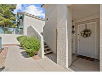 Charming condo front entrance featuring a white security door, a decorative wreath, and steps to the upper level at 701 Harvest Run Dr # 104, Las Vegas, NV 89145