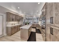 Spacious kitchen features wood cabinets, stainless steel appliances and center island with white countertop at 3001 Walnut Park Ct, Henderson, NV 89052