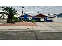 Charming single-story home featuring a blue exterior, mature landscaping, and an attached two-car garage at 6290 Cedarwood Ave, Las Vegas, NV 89103