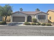 Charming single-story home with a well-maintained front yard and a two-car garage at 7572 Coyote Cave Ave, Las Vegas, NV 89113