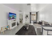 Bright living room featuring a fireplace, a large sofa, and sliding glass doors to the patio at 3008 Saint George St # F, North Las Vegas, NV 89030